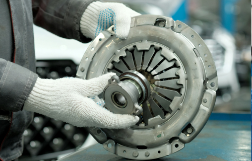 A mechanic holding a car's clutch