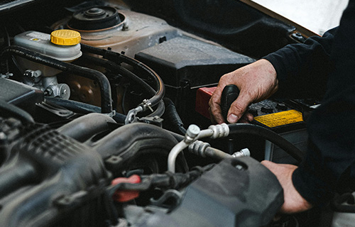 A mechanic working in a car's engine bay