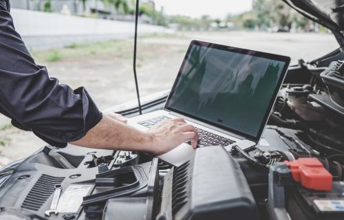 A mechanic performing diagnostics on a vehicle